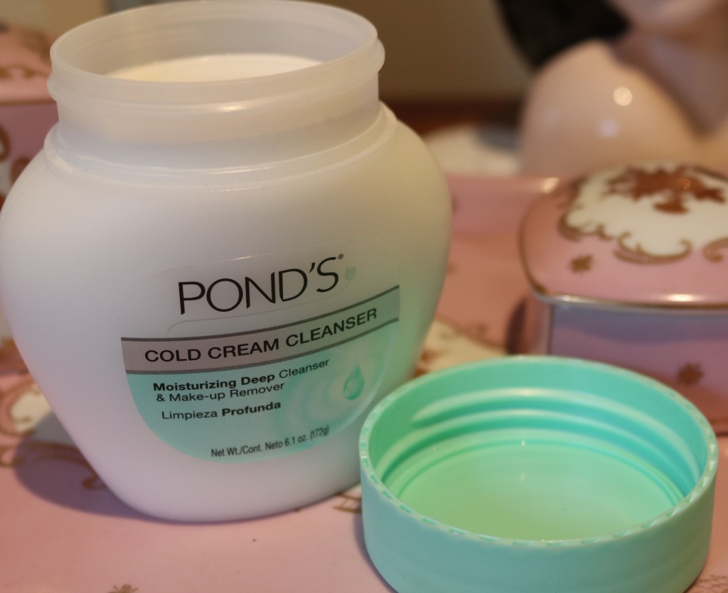 a jar of ponds cold cream. Opened. White with green lid